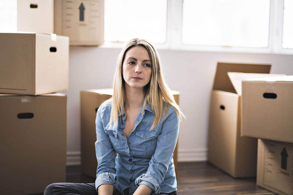 Sad woman surrounded by boxes