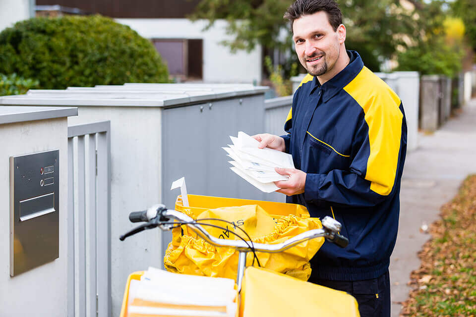  A mailman putting envelopes in a postbox
