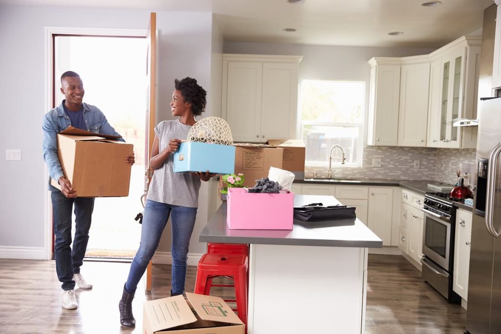 Man and woman carrying boxes into the kitchen after a local move with movers in Bay Area